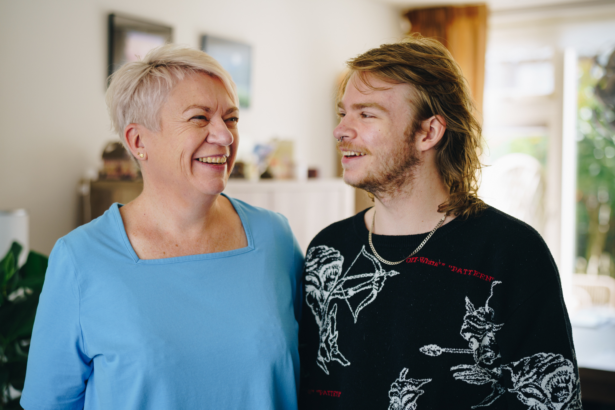 Vrolijk portret van Leanne en haar zoon Sander in de woonkamer