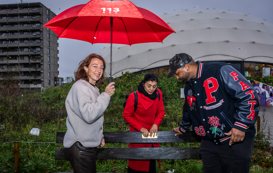 Monique, Tanja en Krulle bevestigen 1K Z1E J3 plaquette op bankje